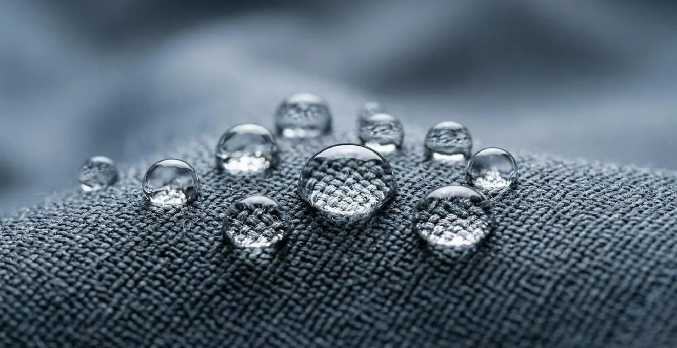 Macro ravvicinata di gocce d'acqua che formano perle sulla superficie di un tessuto tecnico