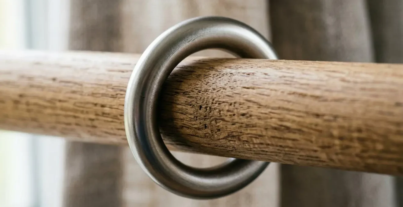 Vista macro ravvicinata di un occhiello metallico satinato su bastone di legno